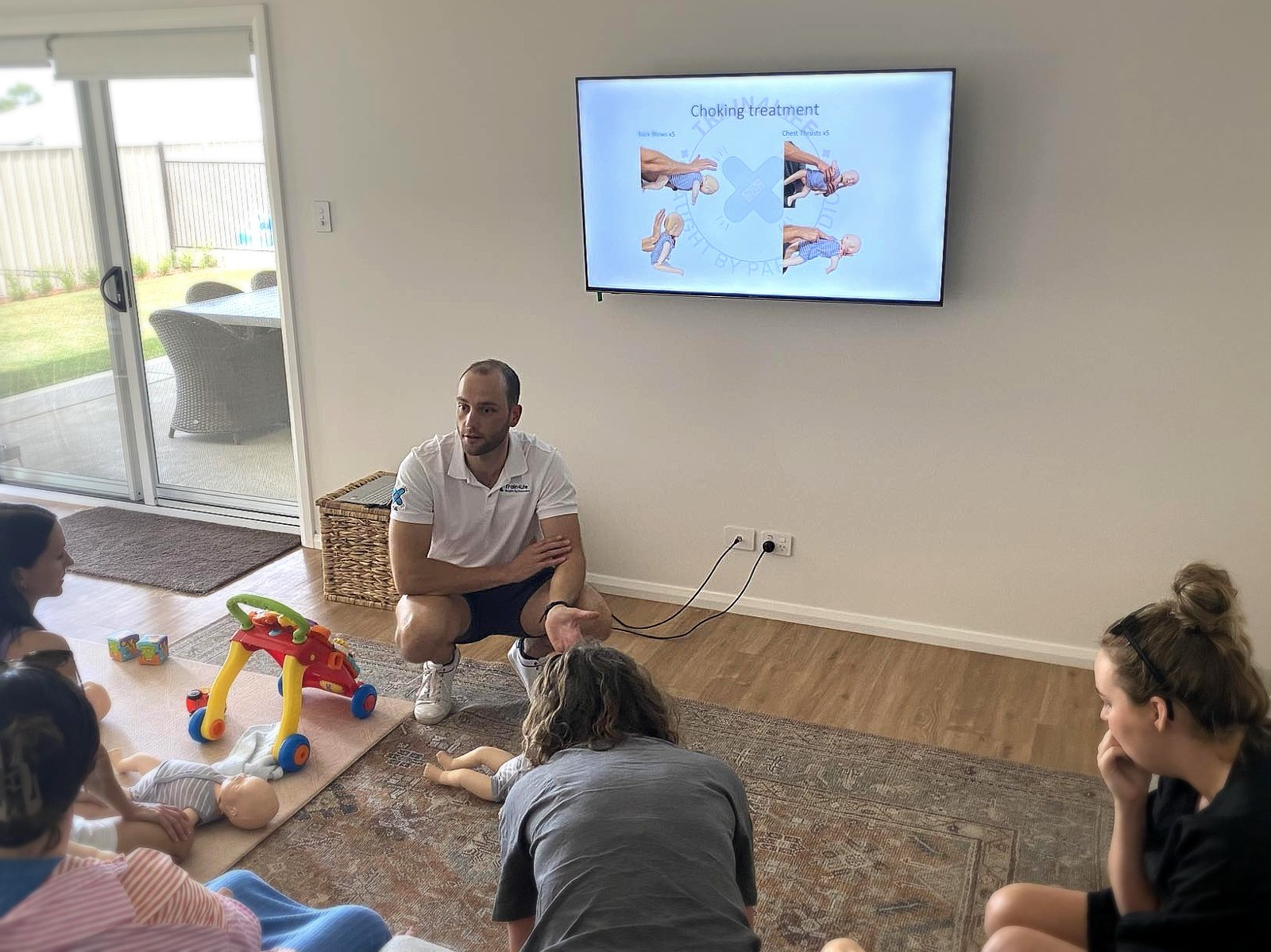 Photo from a Train4Life in-person workshop with a choking treatment training slide on screen